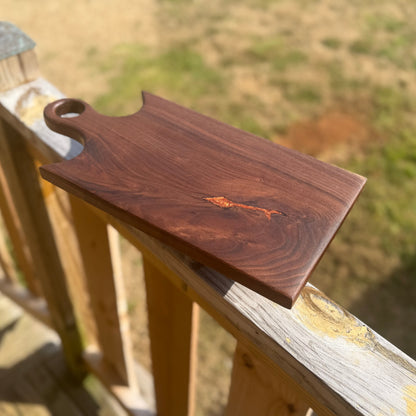 Walnut cutting board with a ring handle.