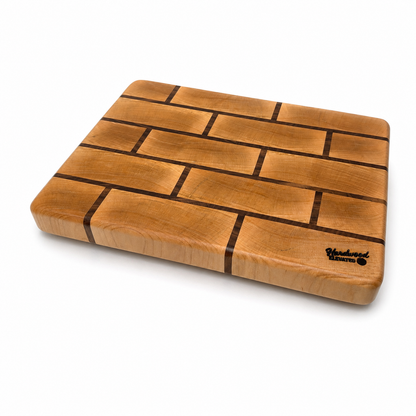 Maple end grain cutting board with walnut brick pattern, angled view on workbench