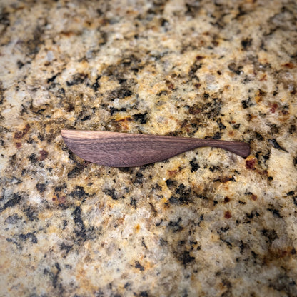 Walnut butter knife in a granite countertop