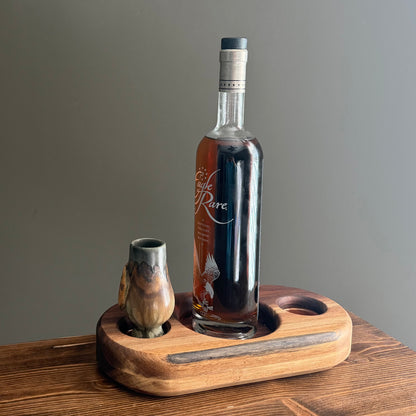 Premium handcrafted wood whiskey display stand with recessed bottle and glass holders, pictured with a bourbon bottle and glencairn glass.
