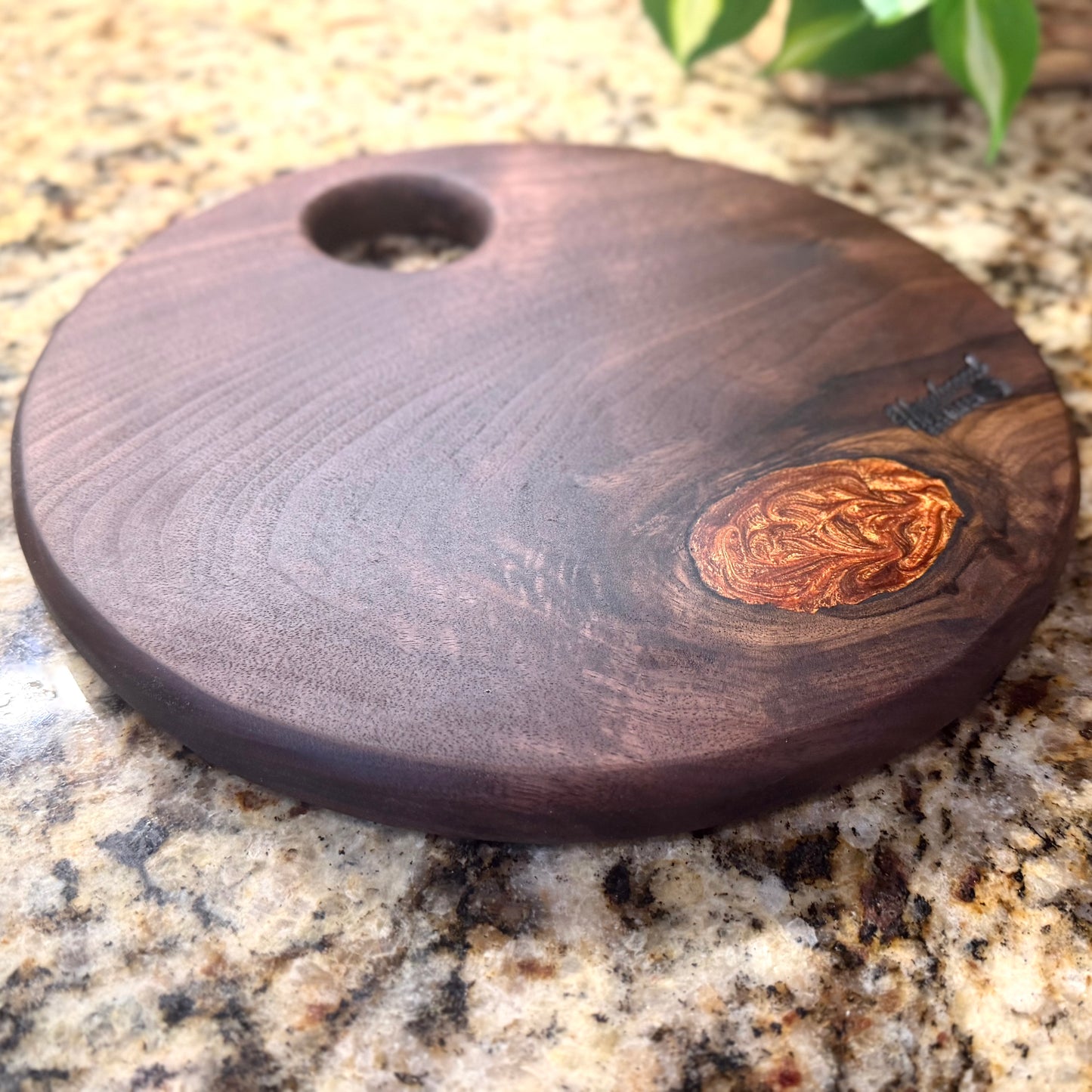 Walnut serving tray with a copper epoxy filled knot on a granite surface